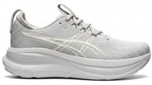 Load image into Gallery viewer, Gray sneaker held in a hand with shelves of shoes and boxes in the background
